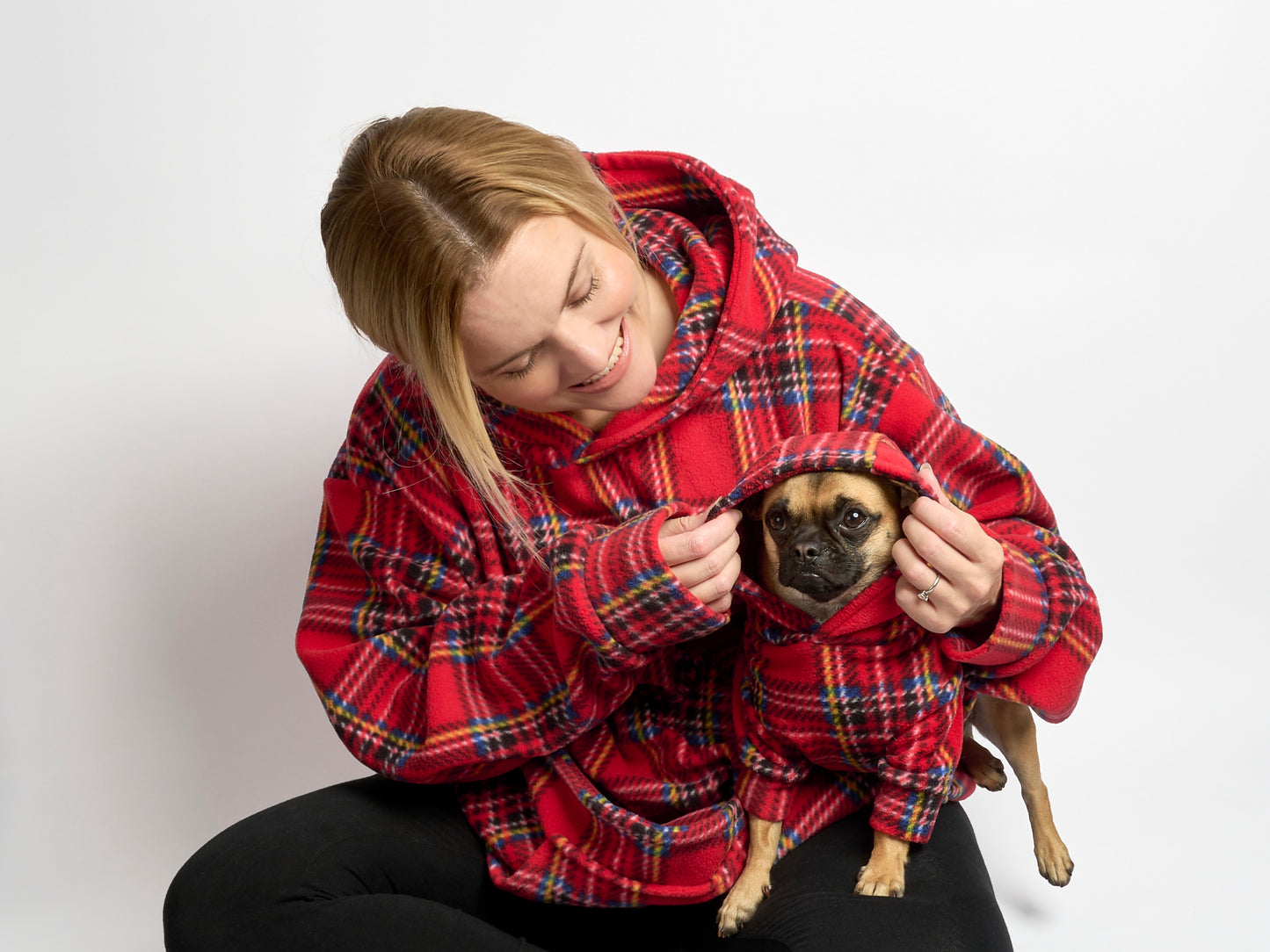 human and small dog in matching hoodies in red tartan fleece